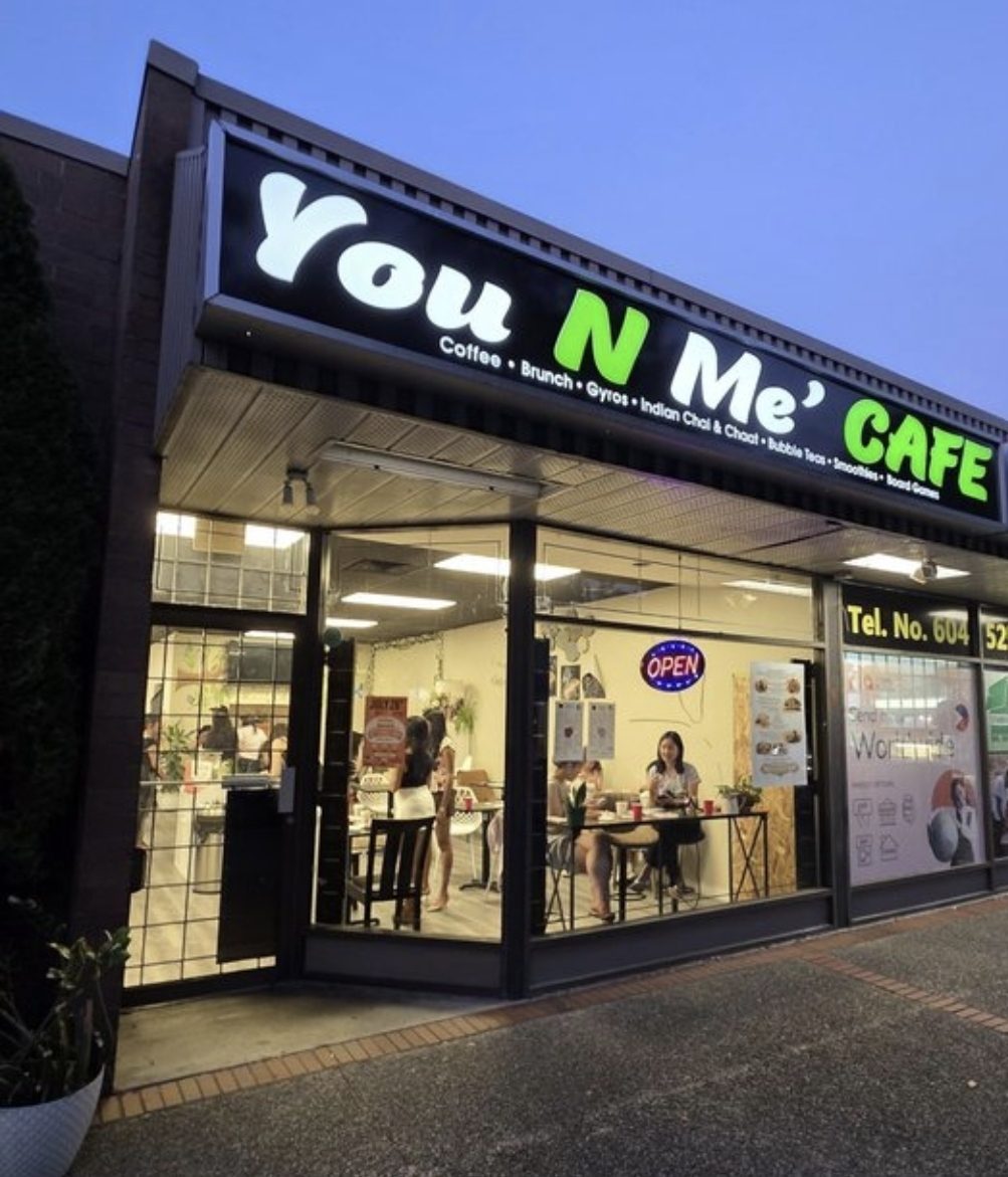 You N Me' Café lit up on 12th Street after dark, guests inside